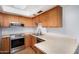 Efficient kitchen with stainless steel appliances and wooden cabinetry at 2154 E Forge Ave, Mesa, AZ 85204