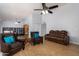 Comfortable living room with leather furniture, ceiling fan, and wood-look flooring at 2154 E Forge Ave, Mesa, AZ 85204