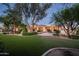 Expansive backyard with lush grass, mature landscaping and covered patio at 22022 N Calle Royale Dr, Scottsdale, AZ 85255