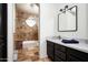 Well-lit bathroom with a tiled shower, marble countertop, and black cabinets at 22022 N Calle Royale Dr, Scottsdale, AZ 85255