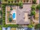 Aerial view of the property featuring a sparkling blue pool, mature landscaping, and a tennis court at 2285 E Plum St, Gilbert, AZ 85298