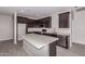 Bright kitchen boasts dark cabinetry, stainless steel appliances, a kitchen island, and wood-look tile at 22895 N 183Rd Dr, Surprise, AZ 85387