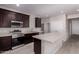 Modern kitchen featuring dark wood cabinets, stainless steel appliances, an island and wood-style flooring at 22895 N 183Rd Dr, Surprise, AZ 85387