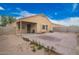 Large backyard features a stained concrete patio, covered porch, and dirt landscape at 23613 W Mobile Ln, Buckeye, AZ 85326