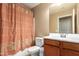 Cozy bathroom featuring a shower-tub combo with an orange-striped curtain and vanity at 23613 W Mobile Ln, Buckeye, AZ 85326