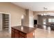 Open-concept kitchen with dark cabinets, a center island, and arched doorways at 23613 W Mobile Ln, Buckeye, AZ 85326