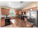 Inviting kitchen with wooden cabinets, an island, and stainless steel appliances at 23613 W Mobile Ln, Buckeye, AZ 85326