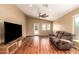 Bright living room with wood floors, a ceiling fan, and access to the backyard at 23613 W Mobile Ln, Buckeye, AZ 85326