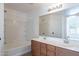Bright bathroom featuring a double vanity with modern faucets and a shower-tub combo with white tile at 2518 W Carson Rd, Phoenix, AZ 85041