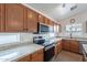 Well-lit kitchen with granite countertops, stainless steel appliances, and wood cabinets at 2518 W Carson Rd, Phoenix, AZ 85041