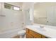 A well-lit bathroom features a shower-tub combo, single sink vanity, and matching wood cabinetry at 2590 S Buckaroo Trl, Gilbert, AZ 85295