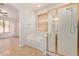 Bathroom featuring a glass shower, tub, and neutral tile at 2590 S Buckaroo Trl, Gilbert, AZ 85295