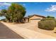 Well-maintained single story home with a two car garage and mature shrubs at 2590 S Buckaroo Trl, Gilbert, AZ 85295