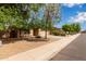 Well-maintained single-story home with desert landscaping and mature shade trees at 2590 S Buckaroo Trl, Gilbert, AZ 85295