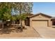 Charming single-story home with a two car garage, desert landscaping, and mature shade trees at 2590 S Buckaroo Trl, Gilbert, AZ 85295