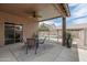 Inviting covered back patio with a table and chairs, overlooking a sparkling pool and landscaped backyard at 2834 E Devon Ct, Gilbert, AZ 85296