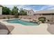 Beautiful kidney-shaped pool features rock waterfall, concrete surround and desert landscaping at 2834 E Devon Ct, Gilbert, AZ 85296