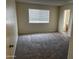 Bedroom with neutral carpet, window, and an open doorway to another room at 3102 N Woodburne Dr, Chandler, AZ 85224