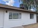 White brick house featuring multiple windows, an exterior light, and a roof-mounted AC unit at 3102 N Woodburne Dr, Chandler, AZ 85224