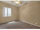 Neutral bedroom featuring a ceiling fan, carpet, and natural light from a window at 34944 N Mirandesa Dr, San Tan Valley, AZ 85143