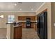 Well-lit kitchen features granite countertops, wood cabinets, and black appliances at 34944 N Mirandesa Dr, San Tan Valley, AZ 85143