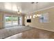 Open concept living room with chandelier and expansive sliding glass doors to the patio at 34944 N Mirandesa Dr, San Tan Valley, AZ 85143