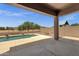 Covered patio area overlooking a pristine pool and landscaped backyard for outdoor enjoyment at 34944 N Mirandesa Dr, San Tan Valley, AZ 85143