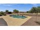 Backyard view of a sparkling pool surrounded by desert landscaping and wrought iron fence at 34944 N Mirandesa Dr, San Tan Valley, AZ 85143