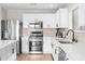Bright kitchen with stainless steel appliances, white cabinets, and quartz countertops at 35360 N 93Rd Way, Scottsdale, AZ 85262