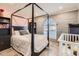 A cozy bedroom with a four-poster bed, a grey brick accent wall, and a baby's crib at 3924 E Cortez St, Phoenix, AZ 85028