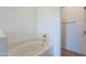 Bathroom soaking tub with white tile surround and chrome fixtures at 41251 W Barcelona Dr, Maricopa, AZ 85138