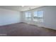 Spacious bedroom with carpet flooring and large windows overlooking the street at 41251 W Barcelona Dr, Maricopa, AZ 85138