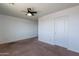 Carpeted bedroom featuring ceiling fan and white trim at 41251 W Barcelona Dr, Maricopa, AZ 85138