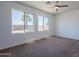 Bright bedroom with ample natural light from large windows, complemented by a modern ceiling fan at 41251 W Barcelona Dr, Maricopa, AZ 85138