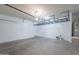 Spacious garage with storage racks, concrete floor, and room for parking at 41251 W Barcelona Dr, Maricopa, AZ 85138