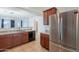 Open-concept kitchen with stainless steel appliances, neutral stone countertops and dark wood cabinets at 41251 W Barcelona Dr, Maricopa, AZ 85138