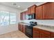 Kitchen with stainless steel appliances, stone countertops, tile floors and dark wood cabinets at 41251 W Barcelona Dr, Maricopa, AZ 85138