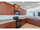 Beautiful kitchen showcasing stainless steel appliances, stone countertops and dark wood cabinets at 41251 W Barcelona Dr, Maricopa, AZ 85138