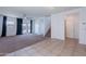 Expansive living room with plush carpeting, ceiling fan, and sliding glass doors to the backyard at 41251 W Barcelona Dr, Maricopa, AZ 85138