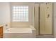 Bathroom featuring a shower and bathtub with neutral tiling at 4143 E Sundance Ave, Gilbert, AZ 85297