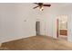 Carpeted bedroom with ceiling fan and view into the bathroom at 4143 E Sundance Ave, Gilbert, AZ 85297