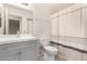 A bathroom featuring a white toilet and sink, plus a shower with a striped curtain at 420 W Yukon Dr # 8, Phoenix, AZ 85027