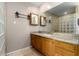 Bright bathroom featuring a large mirror, granite countertops, and a wooden vanity at 4622 E Ellis Cir, Mesa, AZ 85205