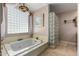 Soaking tub with glass block divider and a decorative light fixture at 4622 E Ellis Cir, Mesa, AZ 85205