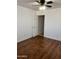 A bedroom with hardwood floor, a ceiling fan with lights and a white door at 4622 E Ellis Cir, Mesa, AZ 85205