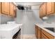 Bright laundry room boasts wood cabinets, washer, dryer, and hanging rack for added convenience at 4622 E Ellis Cir, Mesa, AZ 85205