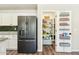 Well-organized pantry with shelving on the door, next to the black stainless refrigerator at 4759 E Woburn Ln, Cave Creek, AZ 85331