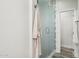 Modern bathroom features a glass-enclosed shower, white tile, and elegant fixtures, next to a white bathrobe at 4920 E Osborn Rd, Phoenix, AZ 85018
