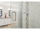 Shower detail featuring decorative tile and glass door, next to a double vanity at 4920 E Osborn Rd, Phoenix, AZ 85018