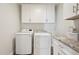 Bright laundry room featuring modern washer and dryer, along with upper cabinets and granite countertop at 4920 E Osborn Rd, Phoenix, AZ 85018